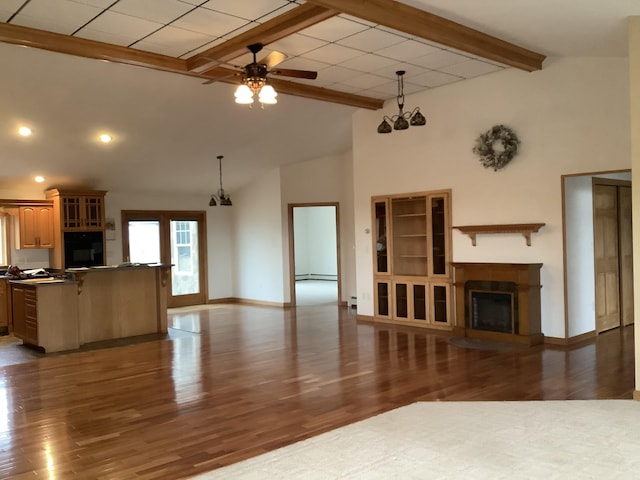 unfurnished living room featuring wood finished floors, beamed ceiling, a baseboard heating unit, a fireplace, and ceiling fan