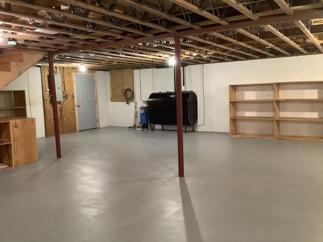 unfinished basement with electric panel and heating fuel