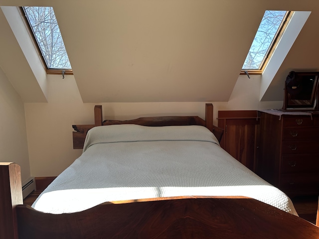 bedroom featuring vaulted ceiling with skylight and baseboard heating