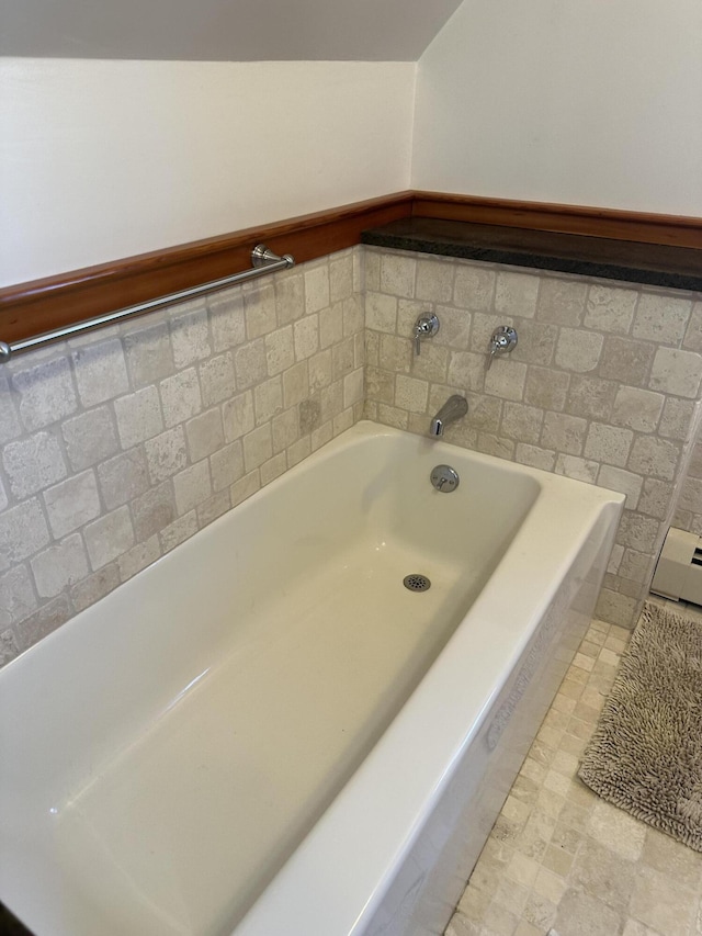 bathroom featuring a bath and a wainscoted wall