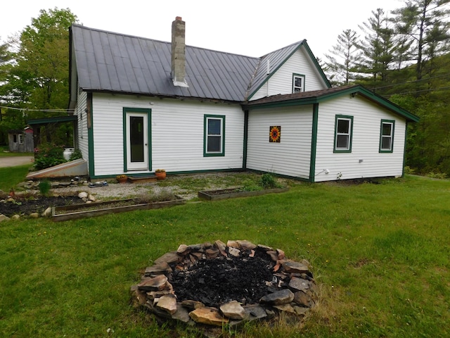 346 Bear River Rd, Newry, ME 04261 - back of house featuring a chimney, a fire pit, a lawn, and metal roof