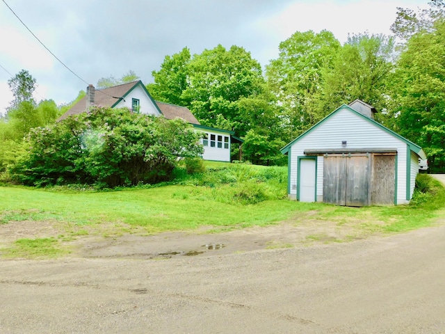346 Bear River Rd, Newry, ME 04261 - view of yard with an outdoor structure, a detached garage, and view of wooded area