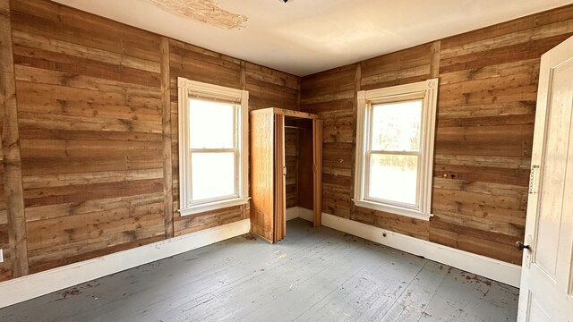 11 Maple St, Milo, ME 04463 - spare room featuring wooden walls, wood-type flooring, and baseboards