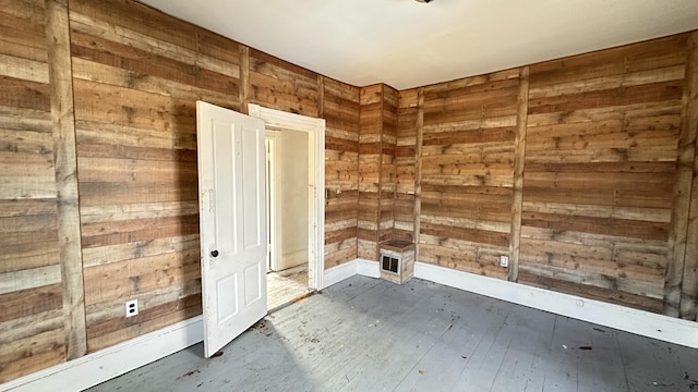 11 Maple St, Milo, ME 04463 - spare room with wood walls and dark wood-type flooring