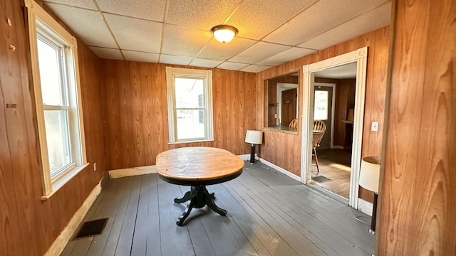 11 Maple St, Milo, ME 04463 - dining space with plenty of natural light, wood walls, baseboards, a drop ceiling, and hardwood / wood-style flooring