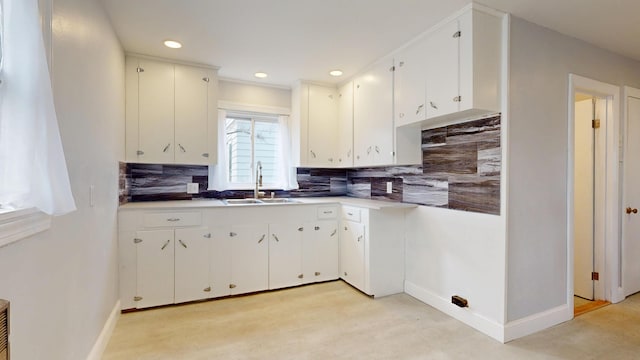 kitchen with baseboards, a sink, and backsplash