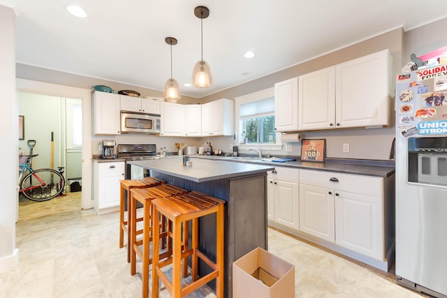 1 Silver Ter, Waterville, ME 04901 - kitchen featuring dark countertops, appliances with stainless steel finishes, white cabinets, and a breakfast bar area