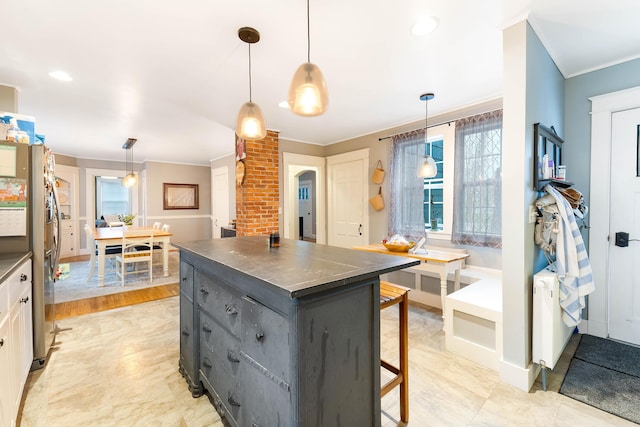 1 Silver Ter, Waterville, ME 04901 - kitchen featuring gray cabinets, a breakfast bar area, crown molding, dark countertops, and a center island