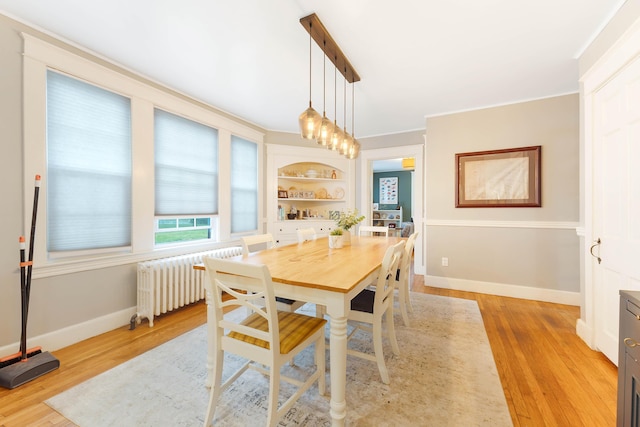 1 Silver Ter, Waterville, ME 04901 - dining room featuring built in shelves, baseboards, light wood finished floors, radiator heating unit, and ornamental molding