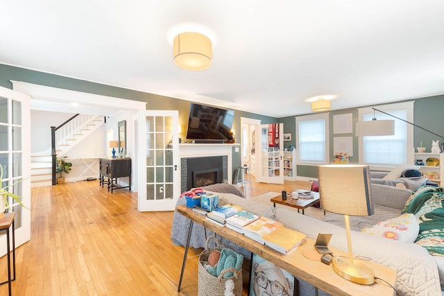 1 Silver Ter, Waterville, ME 04901 - living area featuring a brick fireplace, french doors, stairway, and hardwood / wood-style floors