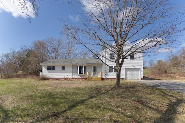 view of front of home featuring an attached garage, driveway, and a front yard