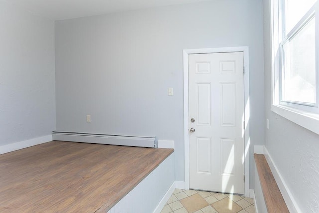 foyer with a baseboard radiator and baseboards