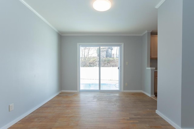 spare room featuring light wood-style flooring, baseboards, and ornamental molding