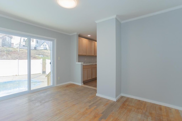 interior space featuring light wood finished floors, baseboards, and ornamental molding
