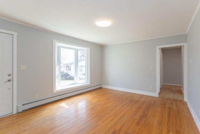 spare room with a baseboard radiator, baseboards, crown molding, and light wood finished floors