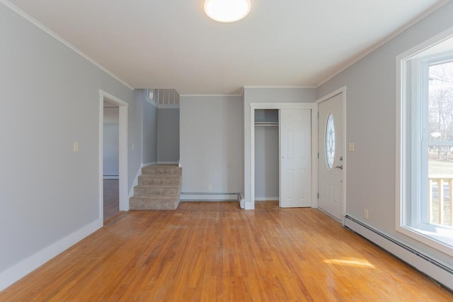 foyer with a baseboard heating unit, light wood-style floors, and plenty of natural light