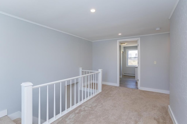 empty room featuring a baseboard heating unit, carpet flooring, recessed lighting, and crown molding