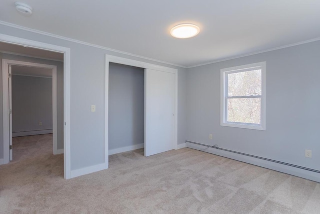 unfurnished bedroom featuring baseboard heating, ornamental molding, and carpet flooring