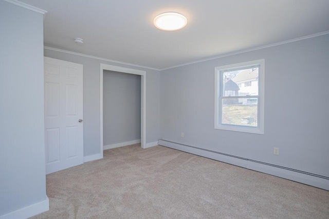 unfurnished bedroom featuring baseboard heating, baseboards, carpet floors, and ornamental molding