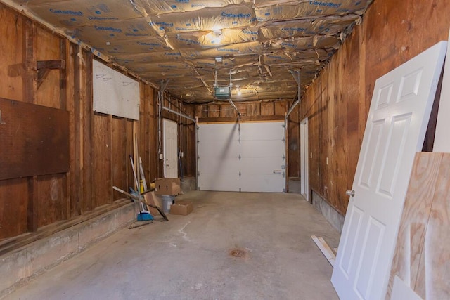 garage with wood walls and a garage door opener