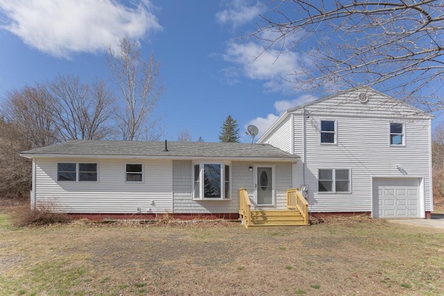tri-level home featuring driveway, a front lawn, and a garage