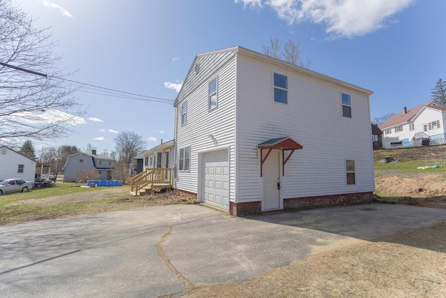 view of side of home with driveway, a residential view, and a garage