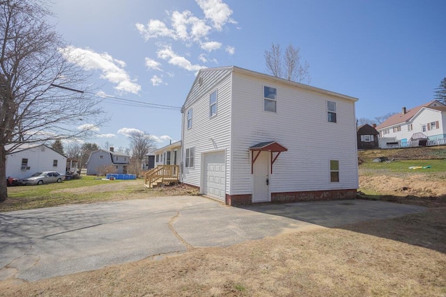 exterior space featuring a residential view, an attached garage, and aphalt driveway