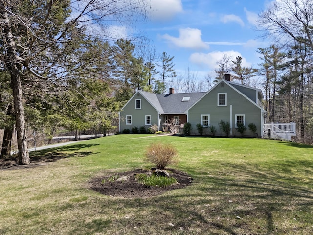 view of front facade with a chimney and a front yard