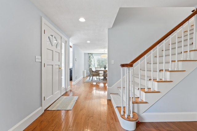 foyer with stairway, baseboards, recessed lighting, and light wood-style flooring
