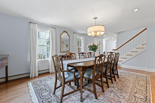dining room with recessed lighting, a wealth of natural light, light wood-style floors, and stairway