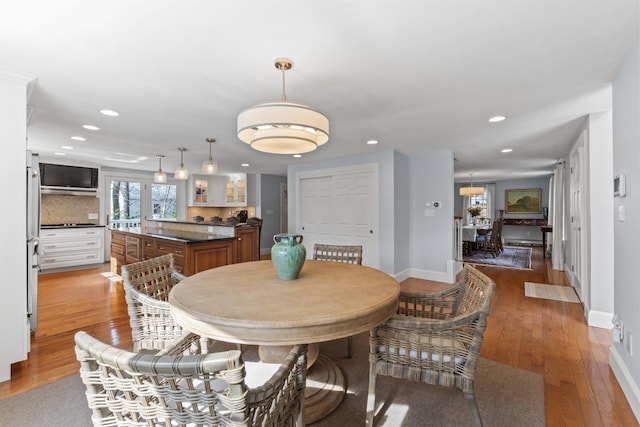 dining area with light wood finished floors, baseboards, and recessed lighting