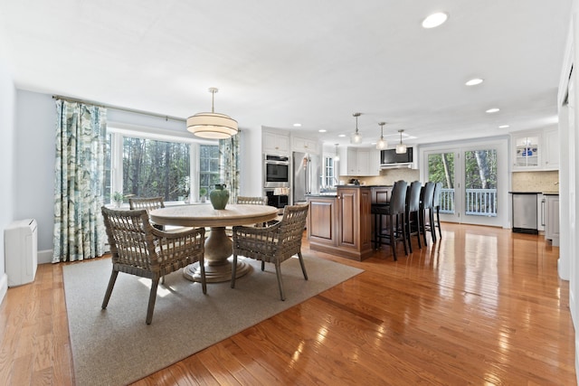 dining space featuring light wood finished floors and recessed lighting