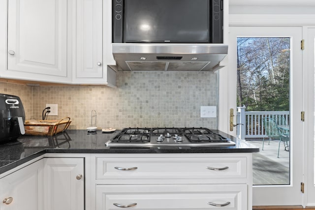 kitchen featuring range hood, stainless steel gas cooktop, decorative backsplash, under cabinet range hood, and white cabinetry
