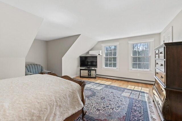 bedroom with lofted ceiling, a wall unit AC, light wood-type flooring, baseboards, and baseboard heating