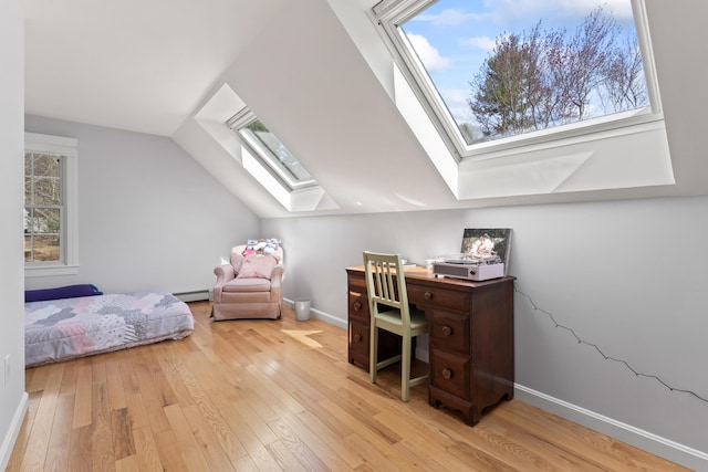 home office featuring a baseboard heating unit, baseboards, wood finished floors, and plenty of natural light