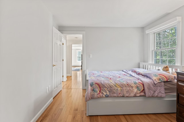 bedroom with light wood-style flooring and baseboards