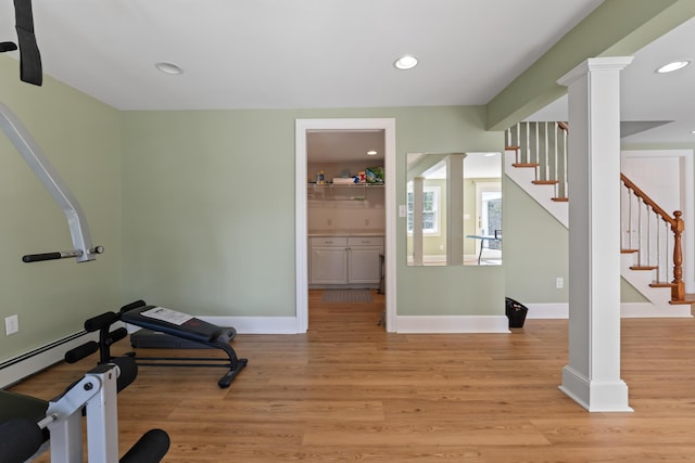 workout room with light wood finished floors, baseboards, recessed lighting, and ornate columns