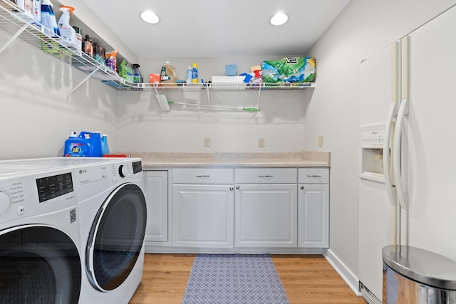 clothes washing area featuring cabinet space, washer and clothes dryer, light wood finished floors, and recessed lighting