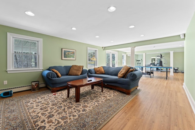 living area featuring recessed lighting, light wood finished floors, a baseboard heating unit, baseboards, and decorative columns