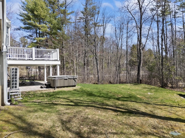 view of yard with a wooden deck, a hot tub, and a patio