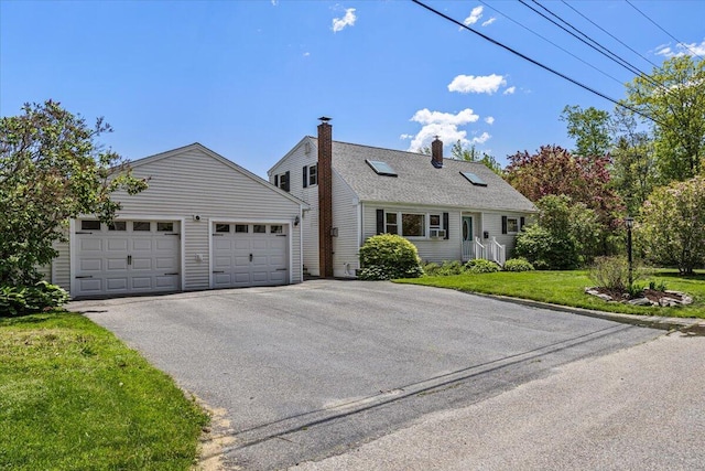 85 Tucker Ave, Portland, ME 04103 - view of front of home with driveway, a chimney, a front lawn, an outdoor structure, and an attached garage