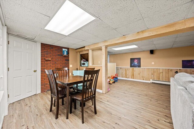 85 Tucker Ave, Portland, ME 04103 - dining room featuring a baseboard heating unit, a drop ceiling, wood finished floors, baseboards, and a wainscoted wall