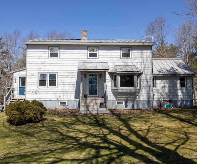 1114 Kennebec Rd, Hampden, ME 04444 - rear view of house featuring a chimney, entry steps, a yard, a standing seam roof, and metal roof