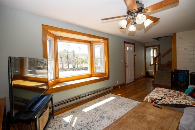 1114 Kennebec Rd, Hampden, ME 04444 - living room with stairway, wood finished floors, a ceiling fan, a baseboard heating unit, and baseboards
