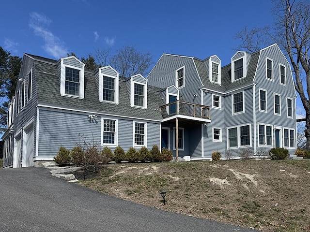 view of front of house featuring a gambrel roof and roof with shingles