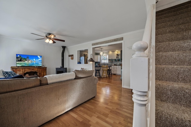 390 Castine Rd, Castine, ME 04421 - living area featuring a wood stove, ornamental molding, light wood-type flooring, and a ceiling fan