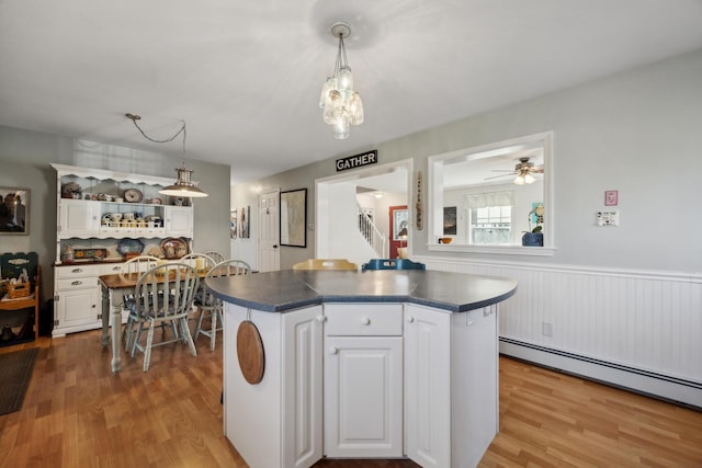 390 Castine Rd, Castine, ME 04421 - kitchen with baseboard heating, dark countertops, wood finished floors, and wainscoting