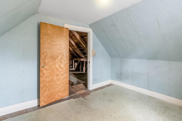 additional living space with vaulted ceiling, carpet, and baseboards