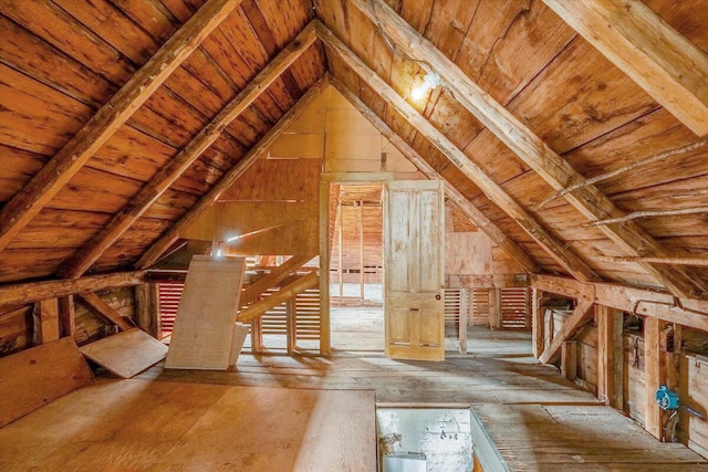 unfinished attic featuring an upstairs landing