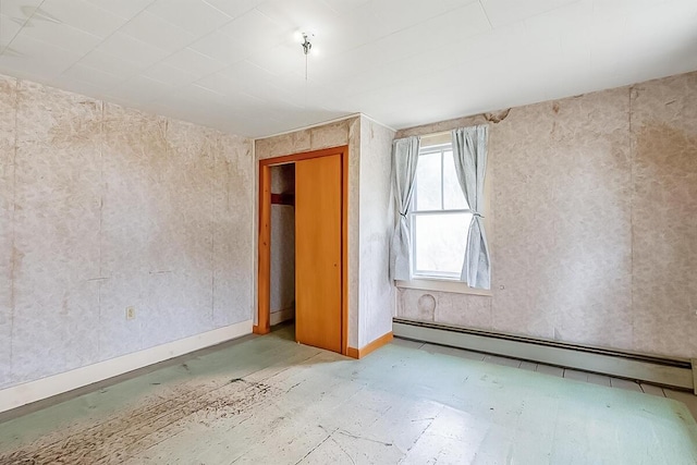 empty room featuring baseboard heating and baseboards